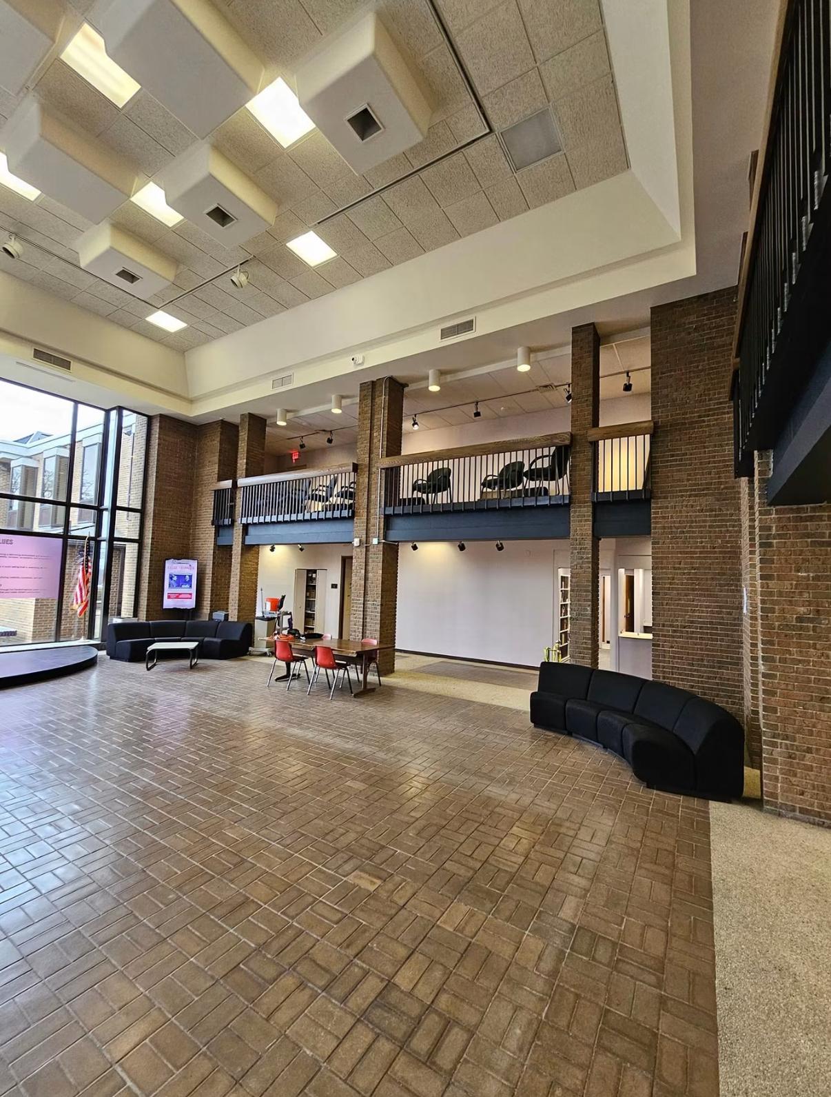 Large commercial lobby with brick columns and a mezzanine level
