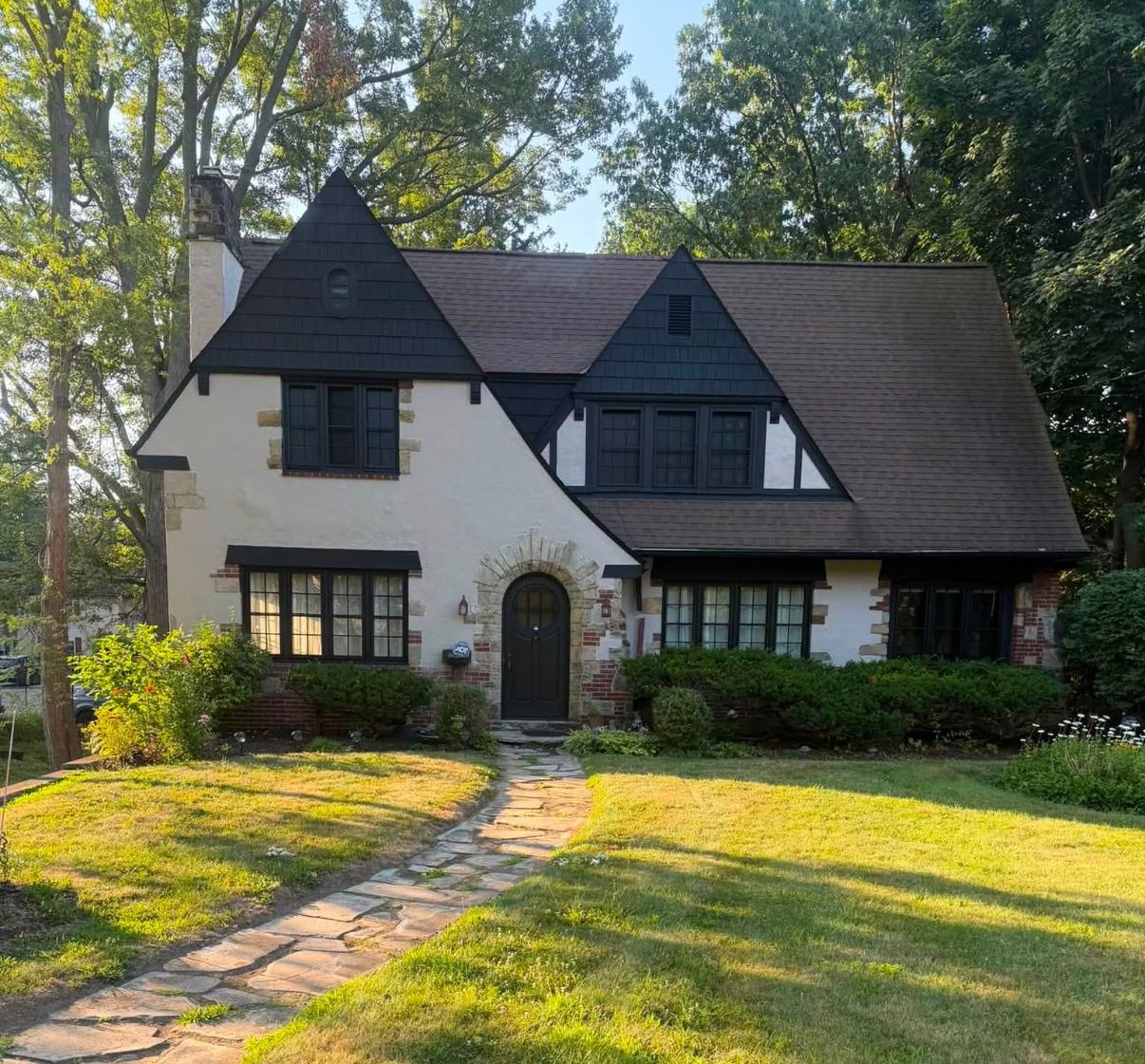 Tudor-style home exterior with dark trim and stonework, a completed Mentor Painting & Staining project